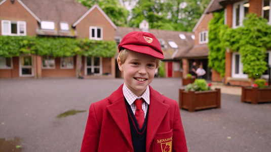 A Moulsford student welcoming visitors to the school with a smile.