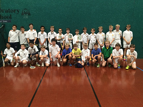 Students playing real tennis, a sport similar to tennis, showcasing their skills and sportsmanship.