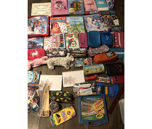 A pile of items including bags and books being sent to Uganda for charity