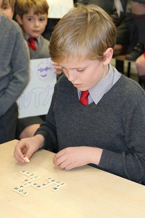 Student playing Bananagrams, a word game that promotes vocabulary, spelling, and critical thinking skills