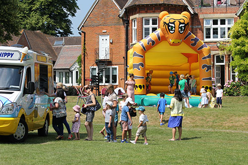 The school fete bustling with activities and attendees, featuring stalls, games, and entertainment for everyone to enjoy