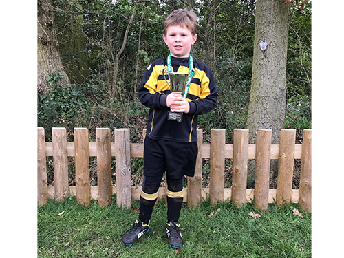 Moulsford student holding a trophy at the London Irish St Patrick's Festival.